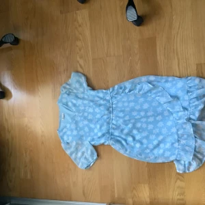 Blommig klänning ifrån Cubus - ljusblå, har fina blommar på sig och använd ungefär 2 gånger. 