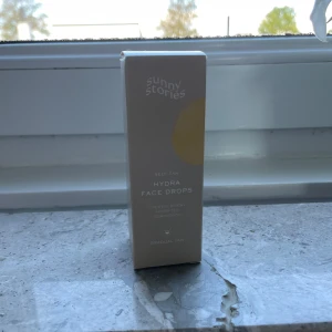 Hydra Face Drops från Sunny Stories - Säljer Hydra Face Drops från Sunny Stories. Det är en self-tan produkt som ger en gradvis solbränna och återfuktar huden. Flaskan är gul med en praktisk pipett för enkel applicering. Perfekt för att få en fräsch och solkysst look! (30ml, inte använd)