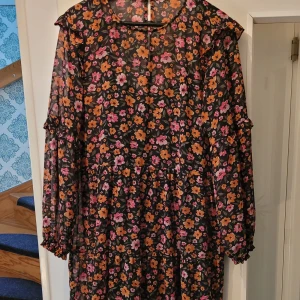 Vadlång tunn klänning - Tunn vadlång klänning med svart underklänning. Härliga färger. Knäpps baktill.