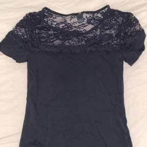 Black top with lace detail on the neckline, tight fit