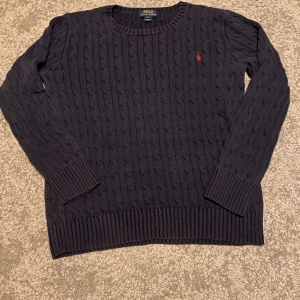 Stickad Ralph Lauren Tjocktröja - Marinblå tröja med röd logga. Knappt använd. Kom med bud! XL i barnstorlek som är ungefär S