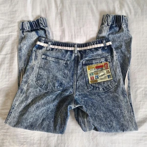 Italienska vintagejeans - Superfina vintagejeans köpta på marknad i Italien, säljer då de blivit för stora. Spräckliga med vita ränder på sidorna, baggy passform med avsmalnande benslut. Hög midja. Sömmen har blivit lite sliten omkring fickorna, se bild. I övrigt som nya!