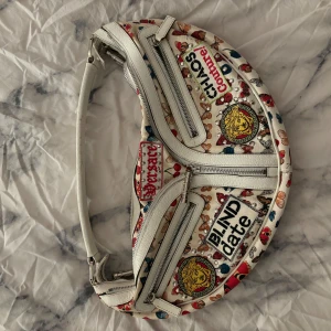 Vintage Versace chaos handväska - Jag säljer min väska jag ärvt från min moster, går ej att köpa från Versace längre endast begagnat. Jag har aldrig använt den, men dock har min moster fast sparsamt. Super fin men inte riktigt min stil därför säljer jag den. 