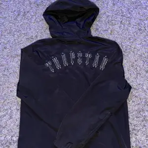 En svart Trapstar jacka/windbreaker. Den är knappt använd och har inga skador alls.