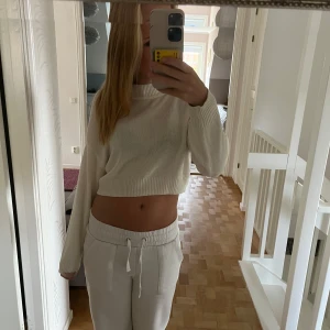 Vit croppad tröja från H&M Divided - Säljer en superfin vit croppad tröja från H&M Divided. Den är stickad och har långa ärmar, perfekt för en chill dag eller att styla upp för en utekväll. Tröjan är i storlek XS och sitter lite löst för en avslappnad look. 🖤