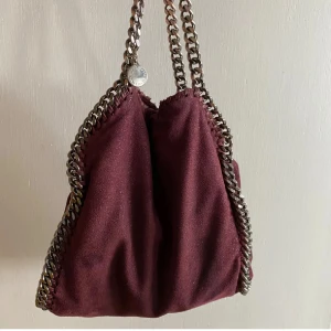 Vinröd Stella McCartney  - Lånade bilder!!!  Säljer nu min Stella McCartney väska som är i bra skick förutom lite missfärgning på kedjan men inget som man tänker på, skriv privat för egna bilder, dustbag och äkthetsbevis kommer med❤️❤️