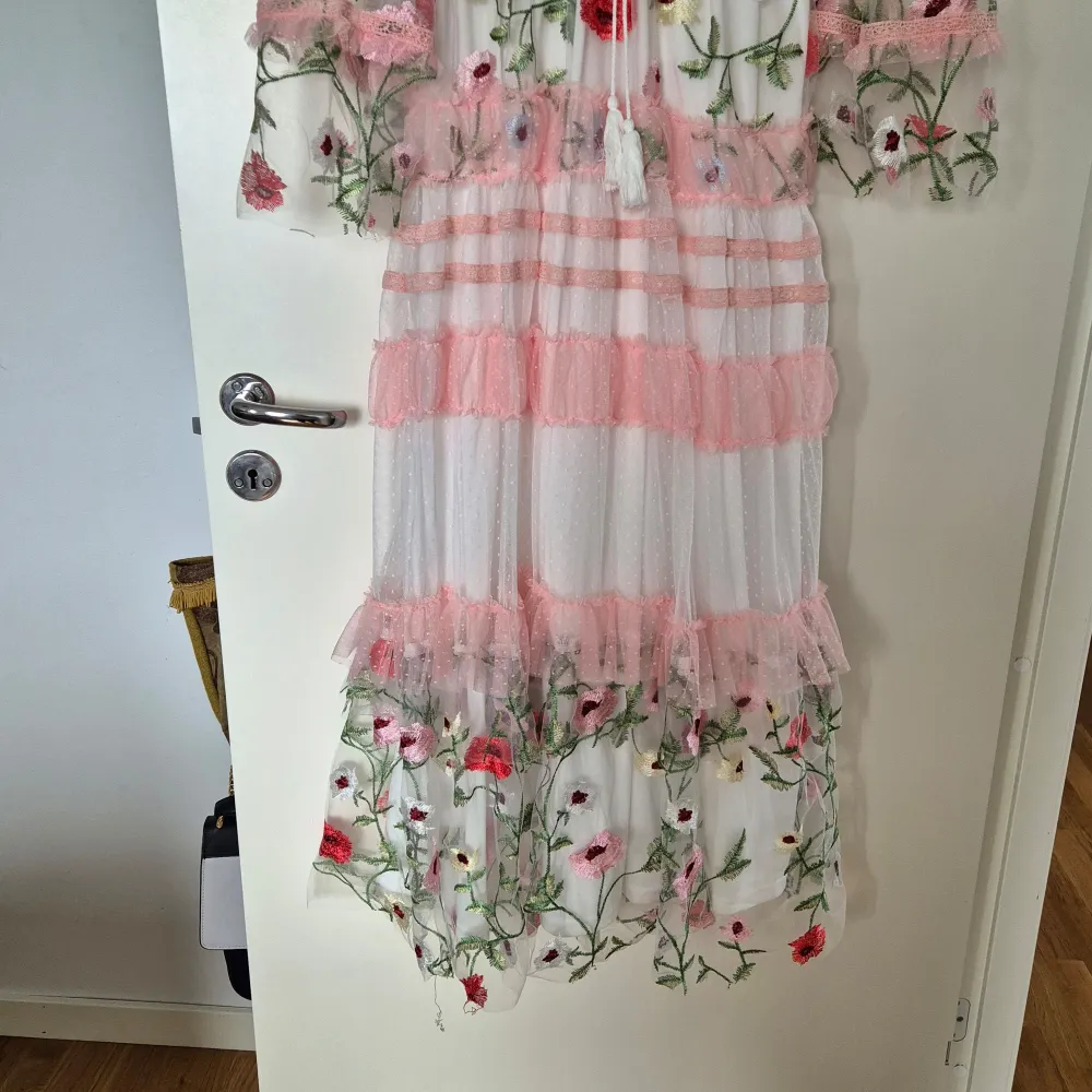 stl S,underbart vacker klänning  .Aldrig använd,felköpt . Passar till de flesta tillfällen . Vit med rosa skirt tyg,genomskinligt i armar med vackert blomdekor över klänningen . Klänningar.