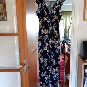 Blommig långklänning v ringad  stl 42/44. - Helt ny och oanvänd långklänning blommönster v ringad med resår .I nyskick 