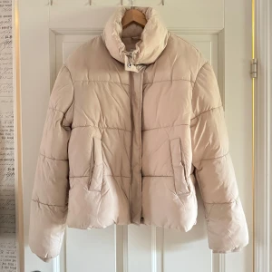 Beige pufferjacket från Nelly - En beige pufferjacket från Nelly, sparsamt använd
