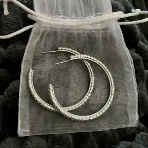 Silver hoops med rhinestones. Tappar inte färgen eller några stenar, bra kvalitet. Andvänts ett fåtal gånger och ser fortfarande nya ut. Andvänder tyvärr inte silver längre å vill sälja. Pris kan diskuteras.