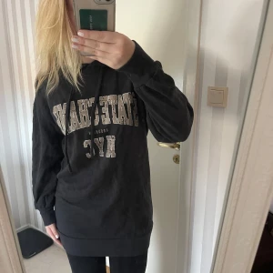 Svart hoodie med text - Säljer en svart hoodieklänning med texten 'Stone Champ NYC' på framsidan. Den har en klassisk design med långa ärmar och en bekväm passform. Perfekt för en avslappnad stil eller en dag på stan. 