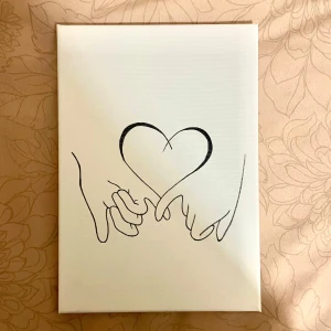 Tavla  - En minimalistisk teckning av två händer som formar ett hjärta med sina fingrar. Teckningen är i svartvitt och tryckt på ett vitt papper. Perfekt för att ge en personlig touch till ditt rum eller som en fin present till någon du bryr dig om. 💖30x21cm