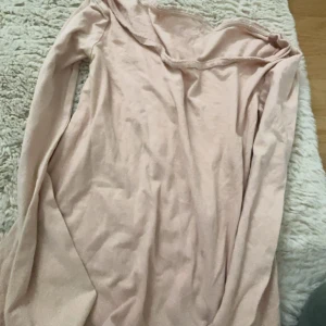 Beige långärmad topp - Säljer en stilren beige långärmad topp. Perfekt för en avslappnad look. Toppen har en enkel design och är gjord i ett mjukt material.