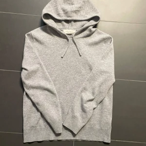 Grå kashmir hoodie från Sayless - Säljer en stilren grå hoodie från Sayless i mjuk kashmir. Perfekt för kyliga dagar med sin bekväma passform och klassiska design. Den har en justerbar huva och skicket är väldigt bra. I princip oanvänd. 