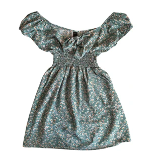 Blommig klänning - Söt blommig klänning i en härlig grön nyans. Perfekt för sommarens alla tillfällen!