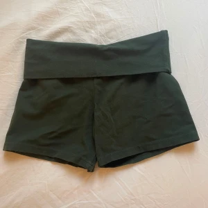 Gröna fold shorts från brandy Melville - Snygga gröna shorts med fold over, perfekta för sommaren eller att mysa hemma i! De är tillverkade i ett mjukt och bekvämt material. Använd ett fåtal gånger, säljer då de blivit för små för mig. Enda defekten är att den tryckta etiketten har suddats bort. 
