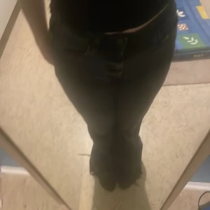 Svarta bootcut byxor från Zara - Snygga svarta bootcut byxor från Zara i storlek S. Byxorna har en hög midja och en stilren design som passar perfekt till olika tillfällen. De är tillverkade i ett bekvämt material och har en fransig detalj vid fållen för en trendig look.