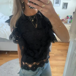 Svart spetsblus - Snygg svart spetsblus med detaljerade virkade mönster och volanger. Superfin topp till våren 💖💐toppen är i storlek M/L men passar även om du har storlek S vanligtvis.