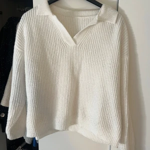 Vit stickad tröja med krage - Säljer en stilren vit stickad tröja med krage och v-ringning. Tröjan har en lös passform och långa ärmar, perfekt för kyligare dagar. Lite nopprig se bild 2. Köpt second hand så vet ej vilket märke de är💕