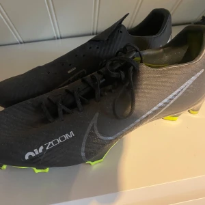 Svarta Nike fotbollsskor - Näst intill oanvända fotbollsskor. Snöret till andra skon ligger i den så det kommer med