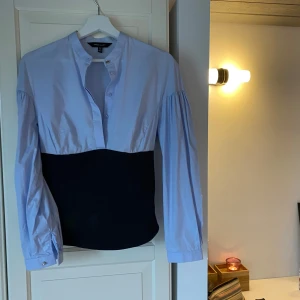 Blus / skjorta  - Blå skjorta med en svart korsettdetalj från Karen Millen. Det svarta är i lite tjockare material och stängs med dragkedja på sidan, och ska sitta tight men tyvärr lite stor för mig