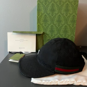ÄKTA Gucci keps  - Säljer denna svarat Gucci keps, i storlek L,Kvitto finns oxå, kepsen är så klart ÄKTA, inga defekter på kepsen, kepsen är i bra skick inga fläckar eller skador, allt på bilden ingår med kepsen, priset är inte hugget i sten, vid frågor hör av er! 