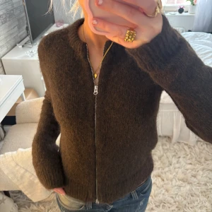 Brun kofta från Weekday - Säljer en mysig brun kofta från Weekday med dragkedja framtill. Koftan har långa ärmar och är tillverkad i ett mjukt material som passar perfekt för kyligare dagar. Perfekt för en stilren och bekväm look. Endast testad🙌🏻