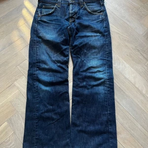 Lee jeans låg midja  - Low Rise Lee jeans med mörk wash. Straight leg och 100% bomull. Mycket bra skick men med lite slitage vid foten. W32/L32 Midja: 40cm innerbenslängd: 72cm bredd vid foten: 21,5 cm