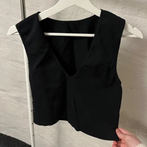 Svart v-ringad topp  - Svart och stretchig topp, passar M,L,XL. kan både ha till vardags och till fest. 