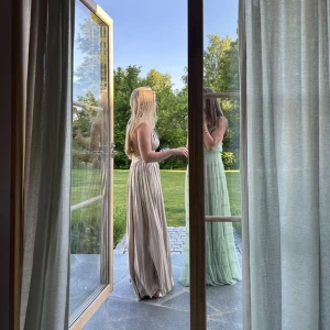 Champagnefärgad långklänning - Säljer min älskade balklänning då jag inte får någon användning för den. Så snygg! Med v-ringad hals, öppen rygg och smala axelband. Klänningen har ett fint fall och är perfekt för sommaren. Endast använd en gång. Nypris 1599 kr. 👏🏽🌸