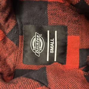 Röd och svart rutig skjorta från Dickies - Säljer en cool röd och svart rutig skjorta från Dickies. Skjortan har långa ärmar och knappar framtill. Perfekt för en avslappnad stil med en touch av klassisk flanellkänsla. 🖤❤️