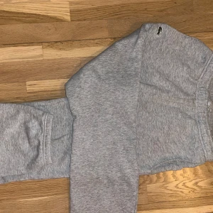 Grå mjukisbyxor från Lacoste - Säljer ett par grå mjukisbyxor från Lacoste. Byxorna har en elastisk midja och en liten krokodil-logga på sidan. Perfekta för en avslappnad stil. Har tyvärr ett litet håll i ena fickan men annars är de helt perfekta!
