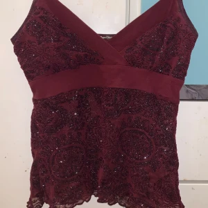 Vinröd spetslinne - Säljer ett elegant vinrött och glittrig top på bra skick💕💕. Perfekt för speciella tillfällen.
