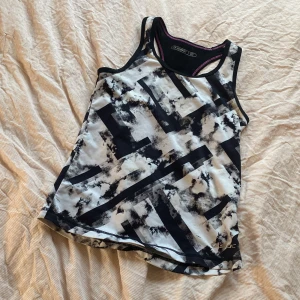 Mönstrad linnetopp från SOC - Säljer en cool mönstrad linnetopp från SOC i svart och vit med gråa inslag. Toppen har ett abstrakt mönster och är ärmlös med en sportig design. Perfekt för träning eller en aktiv dag. 🖤den är väldigt stretchig och absorberar svet. Nästan alldrig använd. 