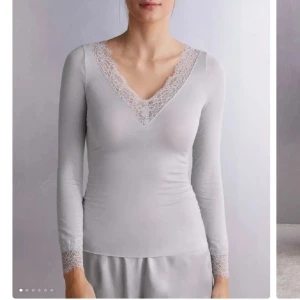 Intimissimi spets topp - Elegant grå långärmad topp med vackra spetsdetaljer vid halsringning och ärmslut. Perfekt för en stilren look. Använd 1 gång, inga små hål, lösa trådar eller något! Som ny helt enkelt🥰