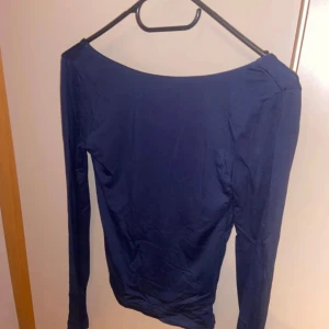 Mörkblå långärmad topp med öppen rygg - Säljer denna marinblå tröja då den aldrig är använd och inte kommer till användning. Den är precis som ny och i superbra skick.