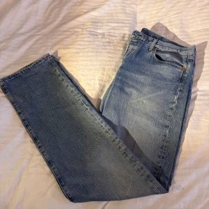 Levis 501 jeans - Klassiska Levis 501 jeans i blå denim. De har en rak passform och är tillverkade i slitstarkt jeansmaterial. Perfekta för en avslappnad stil. 36/36. Litet hål mellan benen.