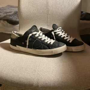 Philippe modell - Snygga svarta sneakers med vita snören och sula. Skorna har en stilren design med rund tå och är perfekta för en avslappnad look. De har en diskret logga på plösen och är tillverkade i skinn.