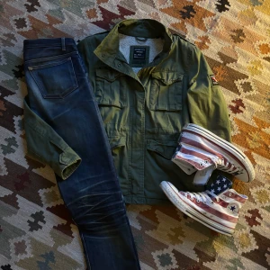 Grön jacka med fleecefoder från SuperDry - En riktigt skön vintage fodrad jacka från SuperDry. Fodrad vilket gör den riktigt varm och skön. Många snygga delatjer. Passar en S. Hör av dig vid frågor eller liknande✌️