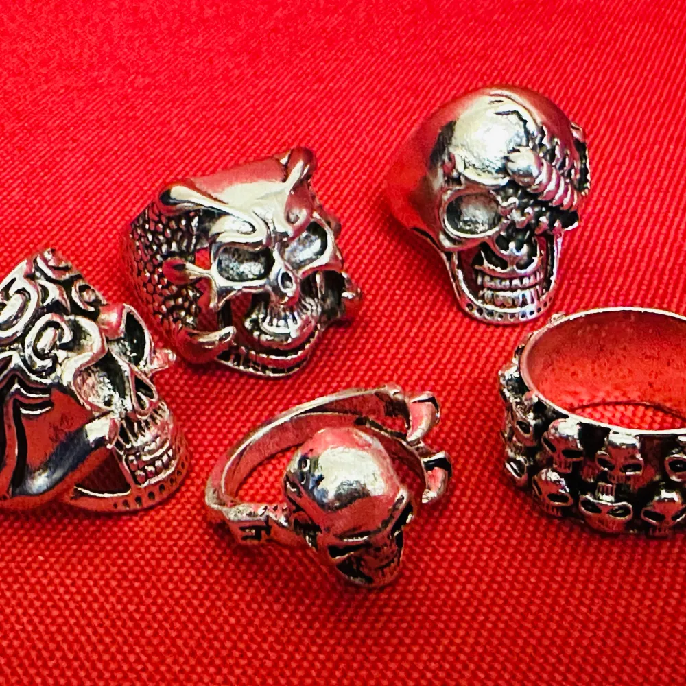 Säljer ett set med fem matchande silverfärgade ringar med dödskallemotiv till fyndpris. Varje ring har en distinkt och detaljerad design. Robust stållegering. Mint kondition. Olika storlekar för att passa olika fingrar. 1,9 - 2,2 cm i innerdiameter, en ring är justerbar storlek. 1,5 - 3 cm höga. Perfekt för att ge en edgy touch till din stil. #alternative #alternativefashion #punk #metal #skulls #skullrings #goth #vintagejewelry #biker #bikerstyle #rock #rockabilly #ring #rings #MC #dödskalle . Asusteet.