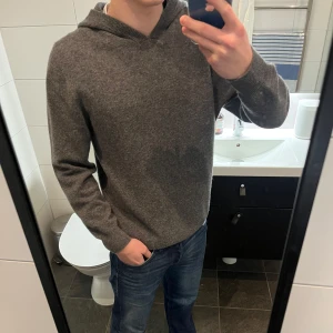 Grå kashmir hoodie - Säljer en stilren grå kashmir hoodie. Mycket bra kvalité och finns inga tecken på användning. Ullen är i fin form och luftig utan noppar som det ska vara. Tröjan är i storlek s och har inte krympt.