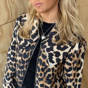 Leopardmönstrad jacka från Ganni - Snygg leopardmönstrad jacka från Ganni med dragkedja framtill. Jackan har en cool design med stora kragar och är perfekt för att sticka ut. Den är långärmad och har en normal passform.