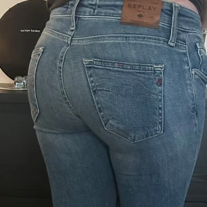 Blå jeans från Replay - Snygga blå jeans från Replay med klassisk femficksdesign och knappgylf. De har en bekväm passform och är perfekta för en avslappnad stil. Märkeslogga på bakfickan och bälteshällor i midjan. Djur finns i hemmet.