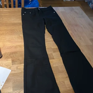 Svarta byxor från BikBok - Snygga svarta bootcut jeans från BikBok i storlek S. Byxorna har en design med utsvängda ben och en stilren look. Perfekta för en chic och enkel stil. Långa i storleken.  