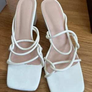 Vita sandaler med snörning - Stilrena vita sandaler med fyrkantig tå och elegant snörning. Perfekta för sommarens alla tillfällen.