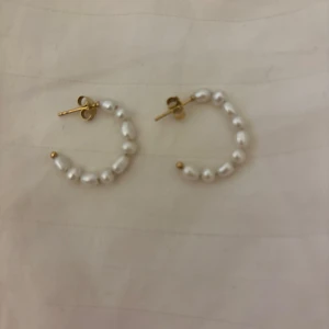 Örhängen med pärlor - Eleganta örhängen i guld med vita pärlor. Perfekta för att ge en klassisk touch till din stil. 