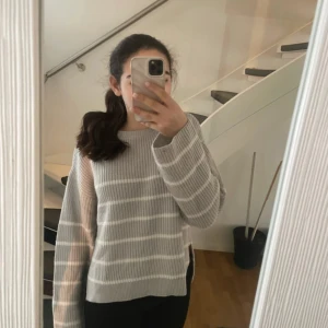 Grå randig tröja  - Säljer en stilren grå randig tröja från Kappahl. Tröjan har långa ärmar och en bekväm passform med ribbade detaljer vid ärmslut och nederkant. Den tö i storlek 170 men passar perfekt i storlek xs och s 