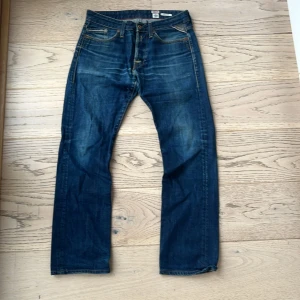 Mörkblå jeans från Replay - Snygga mörkblå jeans från Replay. Byxorna är i storlek 30W och 32L och passar 165-175cm. Märkeslogga på baksidan. En bit av sömmen på vänstra bakfickan. Om du har någon fråga om jeansen är det bara att höra av sig💯Priset kan sänkas vid snabb affär 