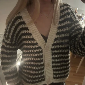 Randig kofta i svart och vit - Säljer en mysig randig kofta i svart och vit med knappar framtill. Från zara! passar mig som har xs