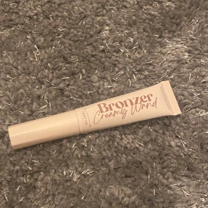 Bronzer Creamy Wand i nyansen Shady Brown - Säljer en Bronzer Creamy Wand från Mekka i nyansen Shady Brown. Denna krämiga bronzer kommer i en praktisk tub och är perfekt för att ge ansiktet en solkysst look. Enkel att applicera och blanda ut för ett naturligt resultat.